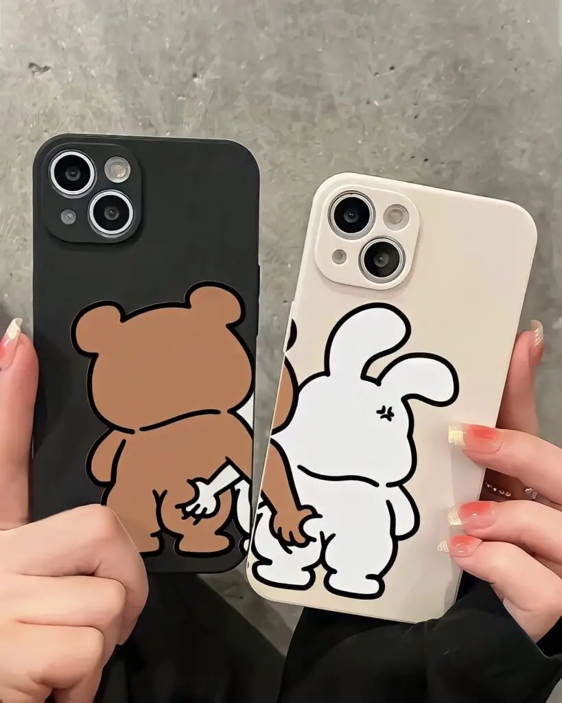 Two people holding smartphones with cartoon-style cases, one bear and one rabbit, against a textured floor background.