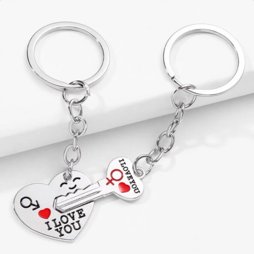 Silver keychains depicting a heart with "I love you" and a matching key, on a white surface.