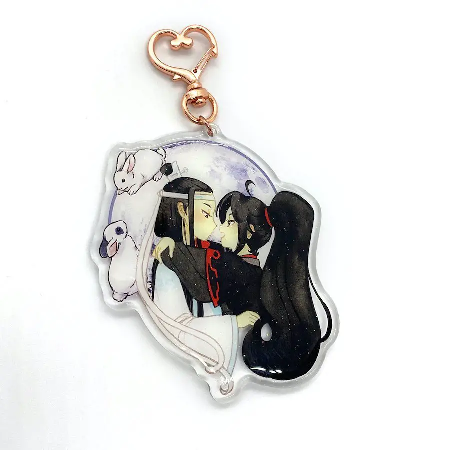 An anime-style keychain depicting a couple embracing passionately, detailed with celestial and nature themes.