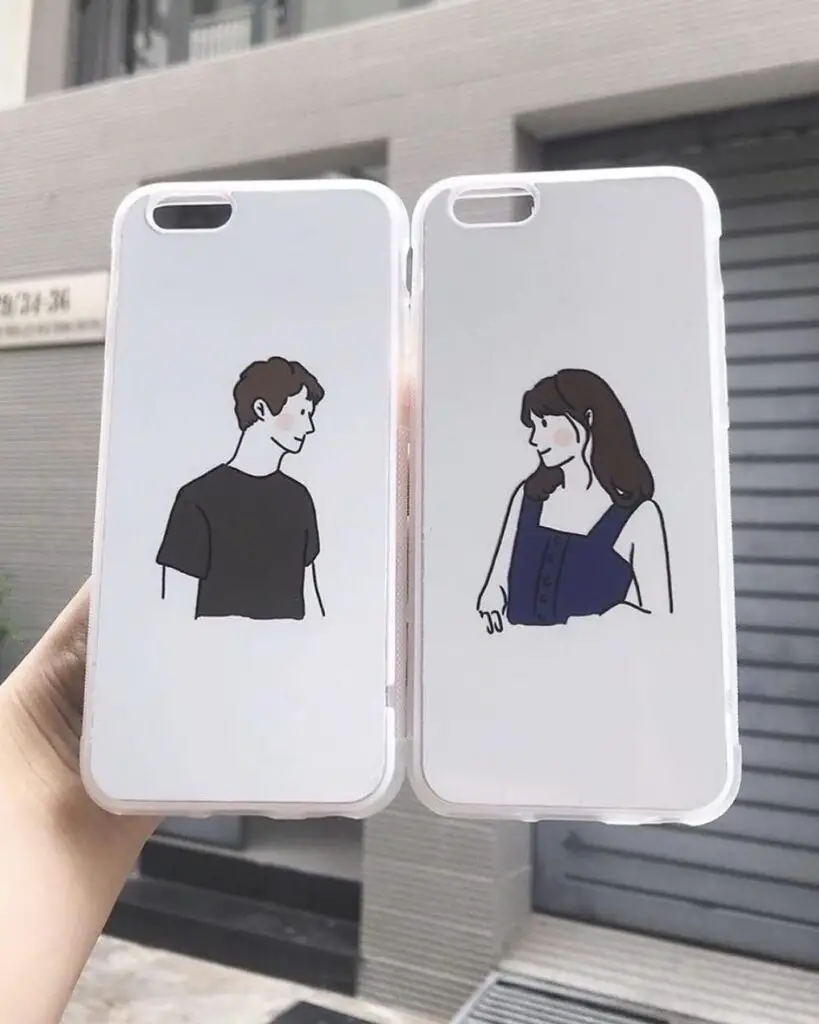 Two iPhone cases with simple line drawings of a man and a woman facing each other, set against a city backdrop.