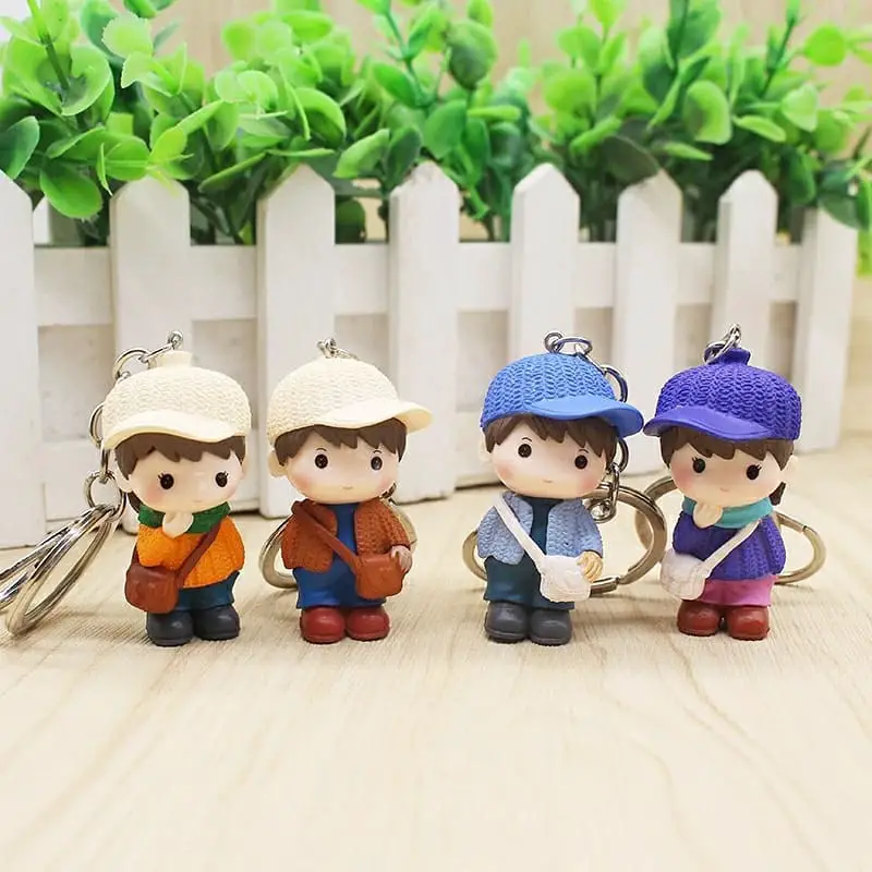 A set of four keychains each depicting couples in different seasonal outfits, ranging from spring to winter.